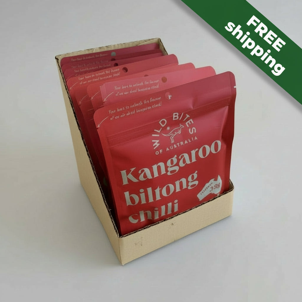 Red packets of Kangaroo Biltong Chilli in a cardboard display box on a light gray background